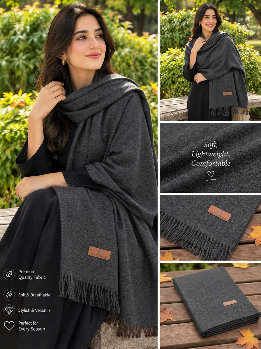 A dark gray shawl with fringe and a small brown leather patch, shown on a model in an outdoor garden setting, with inset detail shots of the fabric texture and folded product.